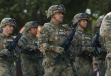 Group of soldiers in camouflage uniforms marching in formation during a military parade