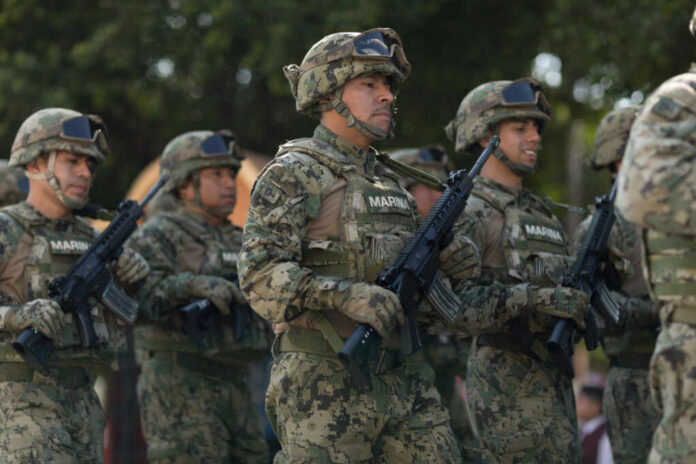 Group of soldiers in camouflage uniforms marching in formation during a military parade