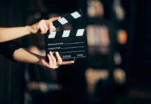 Hands holding a film clapperboard ready for a scene take