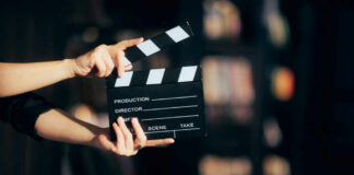 Hands holding a film clapperboard ready for a scene take