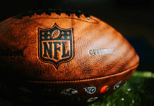 Close-up of an official NFL football with team logos and leather texture