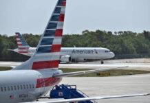 Two American Airlines airplanes at an airport with one taxiing in the background