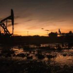 Silhouette of oil pumps against a sunset sky