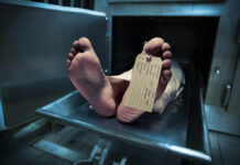 Feet of a deceased person on a metal table with an identification tag