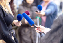 Reporters holding microphones during an interview