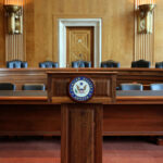 Wooden podium with the United States Senate seal in an empty Senate chamber
