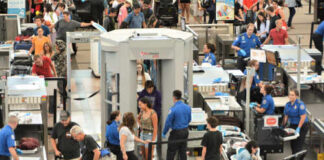 Busy airport security checkpoint with passengers being screened