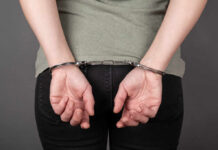 Person with hands cuffed behind their back