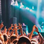 Crowd at a concert with hands raised in excitement