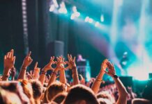 Crowd at a concert with hands raised in excitement