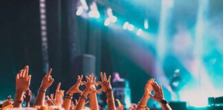 Crowd at a concert with hands raised in excitement