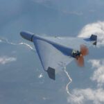 A drone flying high above the clouds with a visible propeller