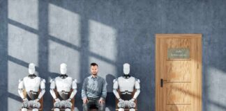 A man sitting between three humanoid robots in a waiting room for a job interview