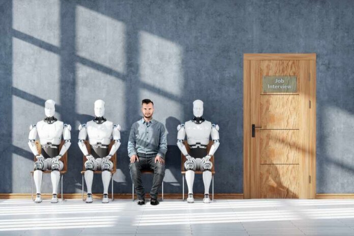 A man sitting between three humanoid robots in a waiting room for a job interview