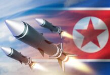 Three missiles launching against a backdrop of the North Korean flag