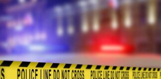 Yellow police tape reading 'DO NOT CROSS' at a crime scene