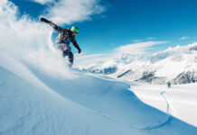 Snowboarder carving through fresh snow on a mountain slope