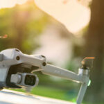 Close-up of a drone with a camera, set against a blurred outdoor background