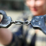 Close-up of handcuffs being held by a person