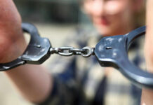 Close-up of handcuffs being held by a person
