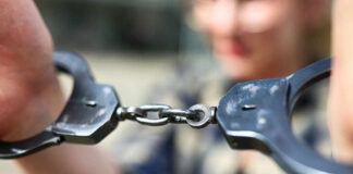 Close-up of handcuffs being held by a person
