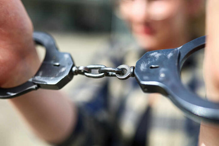 Close-up of handcuffs being held by a person