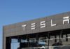 Exterior view of a Tesla dealership with the logo prominently displayed