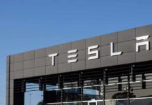 Exterior view of a Tesla dealership with the logo prominently displayed