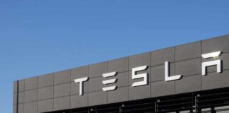 Exterior view of a Tesla dealership with the logo prominently displayed