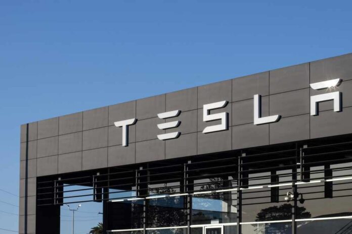 Exterior view of a Tesla dealership with the logo prominently displayed