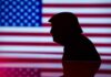 Silhouette of a person against an American flag background
