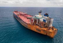 Aerial view of a large, rusty oil tanker in the ocean