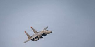 A military fighter jet flying against a clear sky