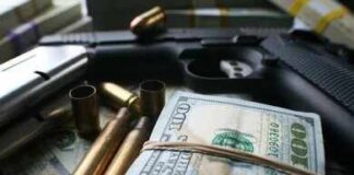 A handgun surrounded by cash and bullet casings