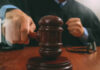 A judge striking a gavel on a wooden desk