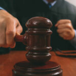 A judge striking a gavel on a wooden desk