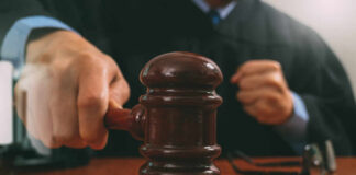 A judge striking a gavel on a wooden desk