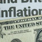 Sudden Inflation Surge Shocks US Families Close-up of a US dollar bill with a newspaper headline about inflation