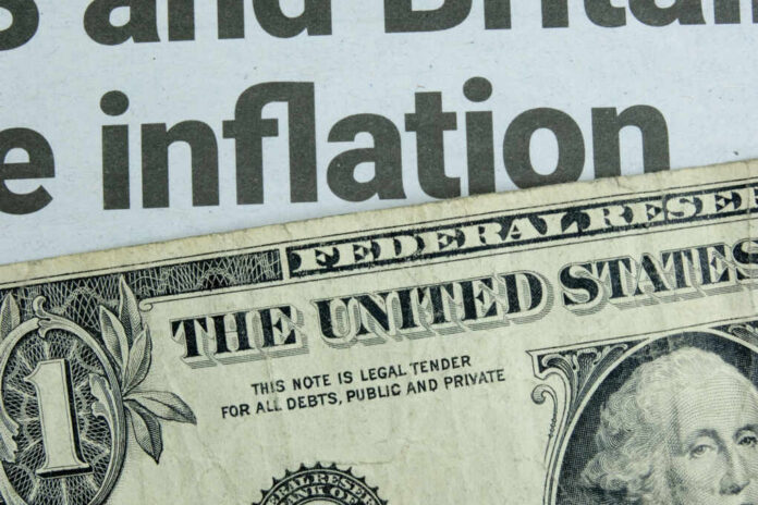 Close-up of a US dollar bill with a newspaper headline about inflation