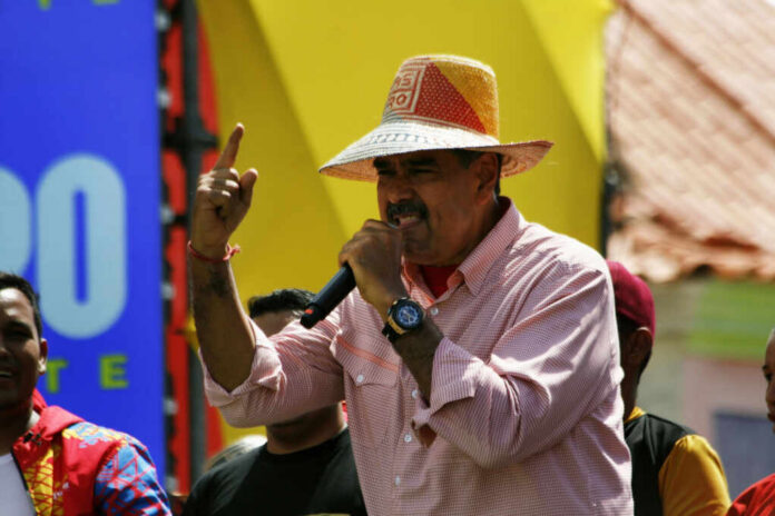 shutterstock2496211777jpg A man in a straw hat passionately speaking into a microphone at a lively outdoor event