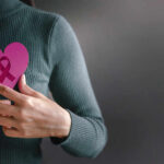 Cancer-Causing Virus in Milk? Shocking Link Person holding a pink heart with a ribbon symbol