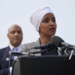 Congresswoman PROTECTED Amid Billion-Dollar Fraud Probe Ilhan Omar speaking at a press conference with André Carson in the background