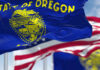 Oregon state flag waving in front of an American flag