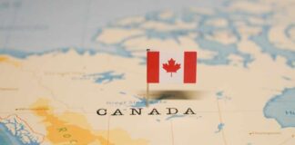 A small Canadian flag placed on a map indicating Canada