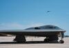 A B-2 stealth bomber on an airfield under a clear blue sky