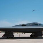 A B-2 stealth bomber on an airfield under a clear blue sky