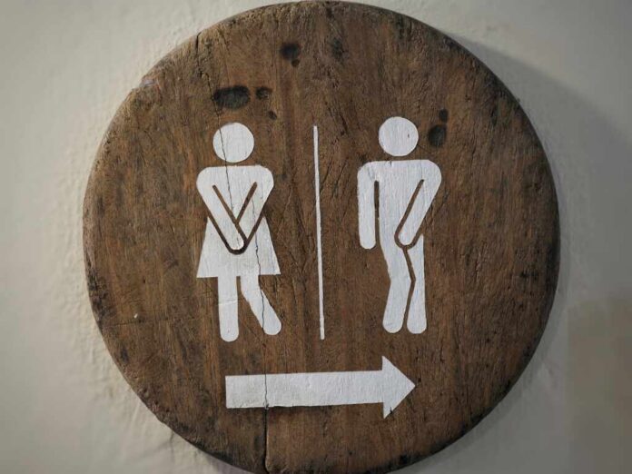 Wooden restroom sign indicating mens and womens facilities with directional arrow