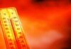 Thermometer showing high temperature against a red hot background