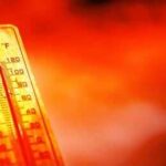 Thermometer showing high temperature against a red hot background