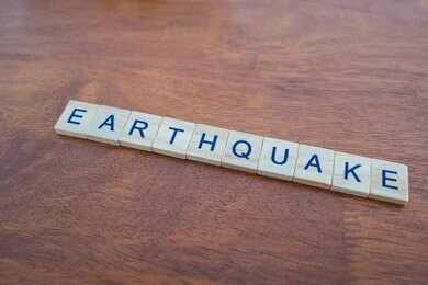 Scrabble tiles spelling earthquake on a wooden table